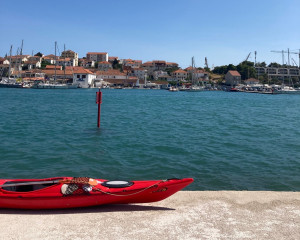 Kroatischer Hafen mit Häusern und rotem rotem Kajak