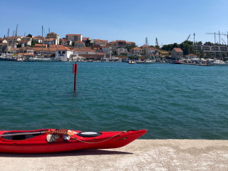 Kroatischer Hafen mit Häusern und rotem rotem Kajak